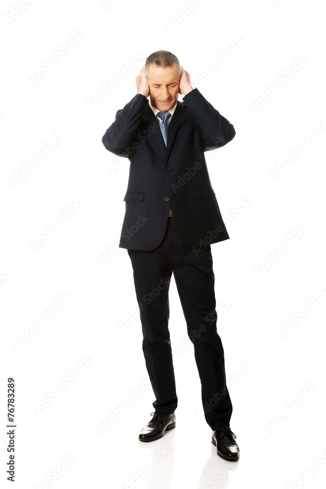 Full length tired man covering ears with hands Full length tired man covering ears with hands