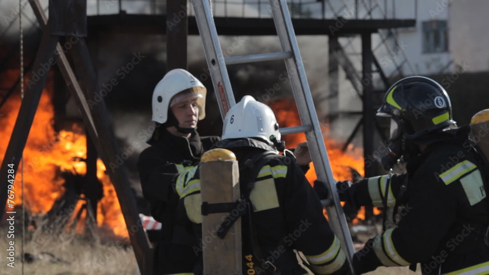 Firefighters climb up the ladder in a fire Firefighters climb up the ladder in a fire