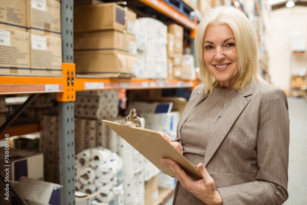 Smiling female manager holding clipboard Smiling female manager holding clipboard
