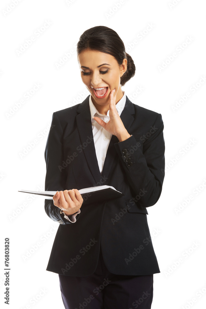 Surprised businesswoman reading her notes
