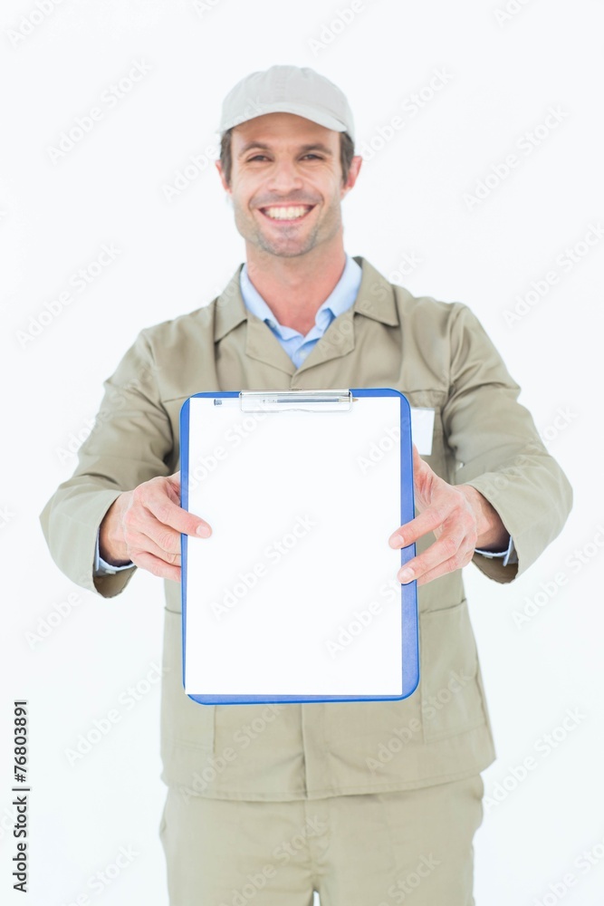 Happy delivery man showing blank paper on clipboard Happy delivery man showing blank paper on clipboard