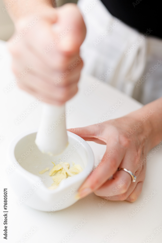 Female hands with a mortar and garlic Female hands with a mortar and garlic
