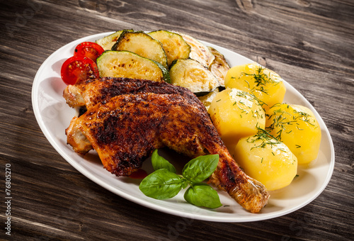 Barbecued chicken leg with boiled potatoes and vegetables