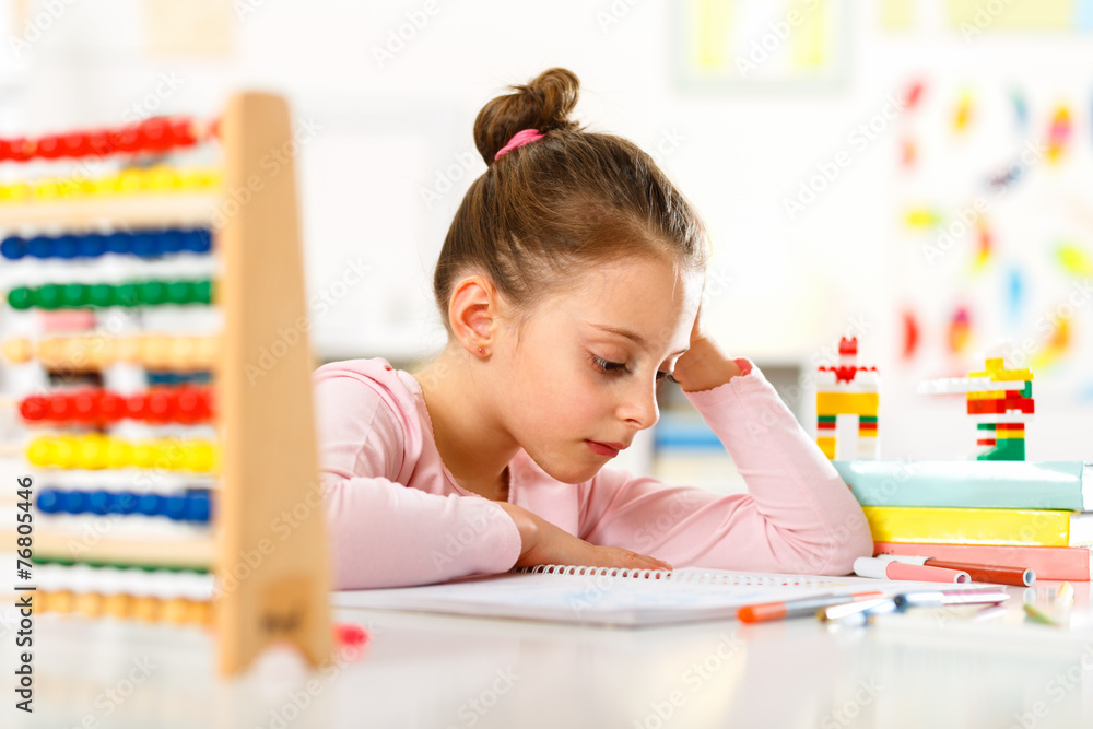 Fototapeta premium Little girl is doing homework.