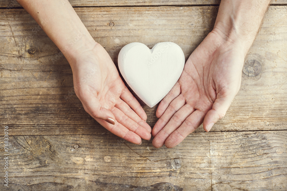 Hands of man and woman holding a heart together. Hands of man and woman holding a heart together.