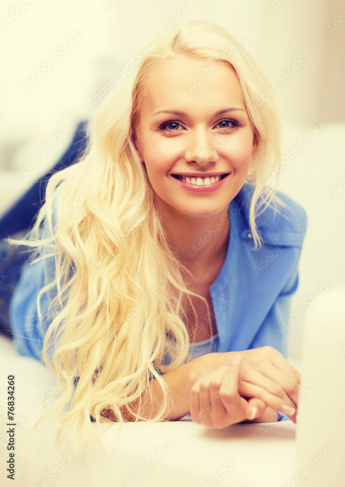 smiling young woman lying on sofa at home smiling young woman lying on sofa at home