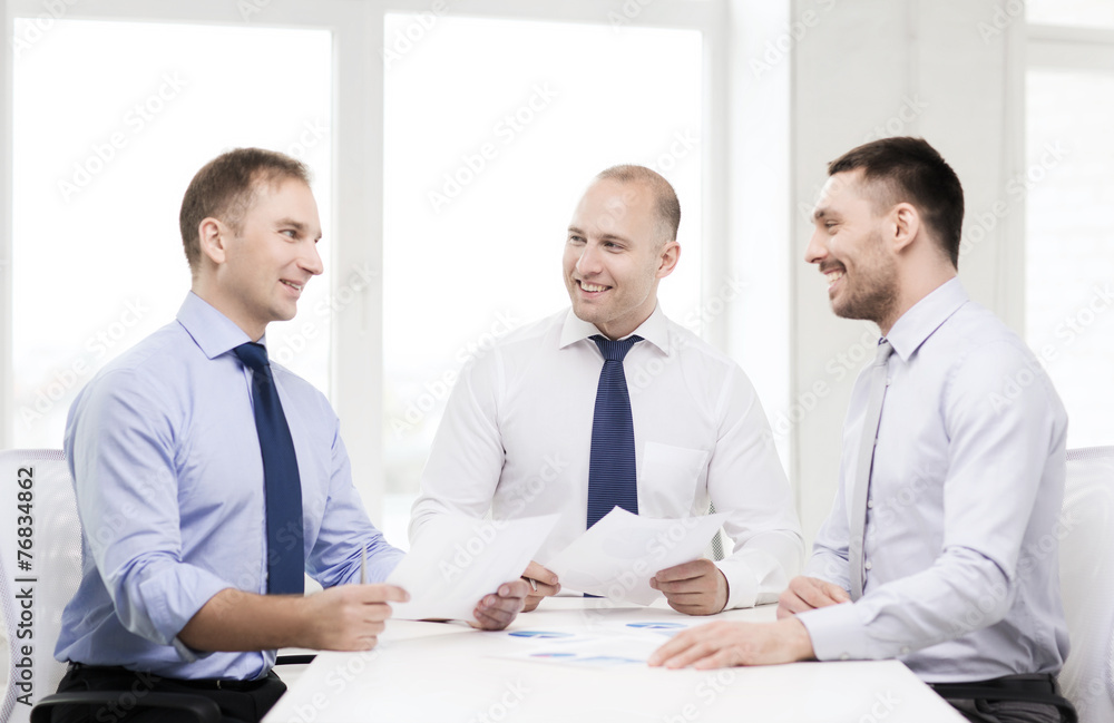 smiling businessmen with papers in office smiling businessmen with papers in office