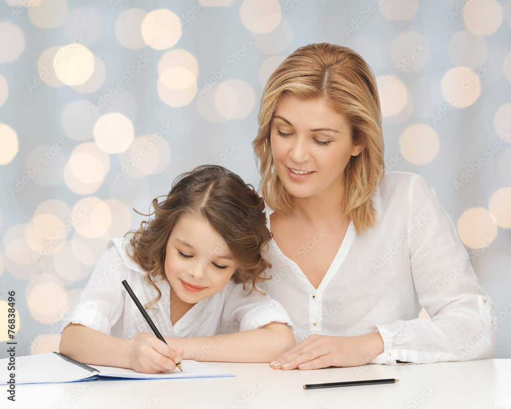 happy mother and daughter writing in notebook happy mother and daughter writing in notebook