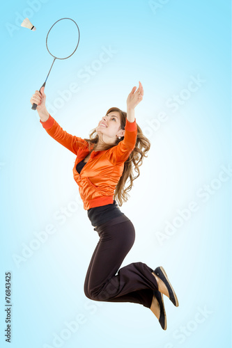 Girl playing badminton jumping catching shuttlecock with racket