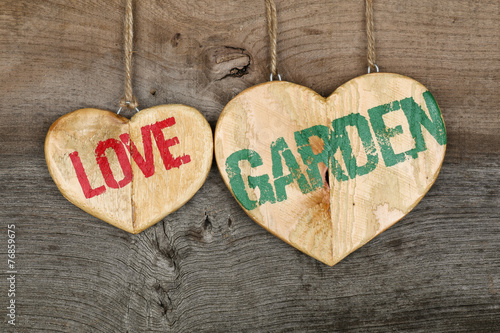 Love Garden message wooden heart sign on rough grey background