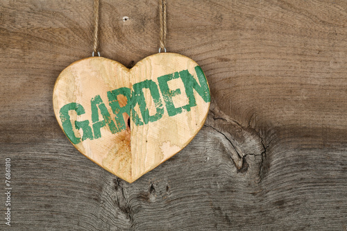 Love Garden message wooden heart sign on rough grey background
