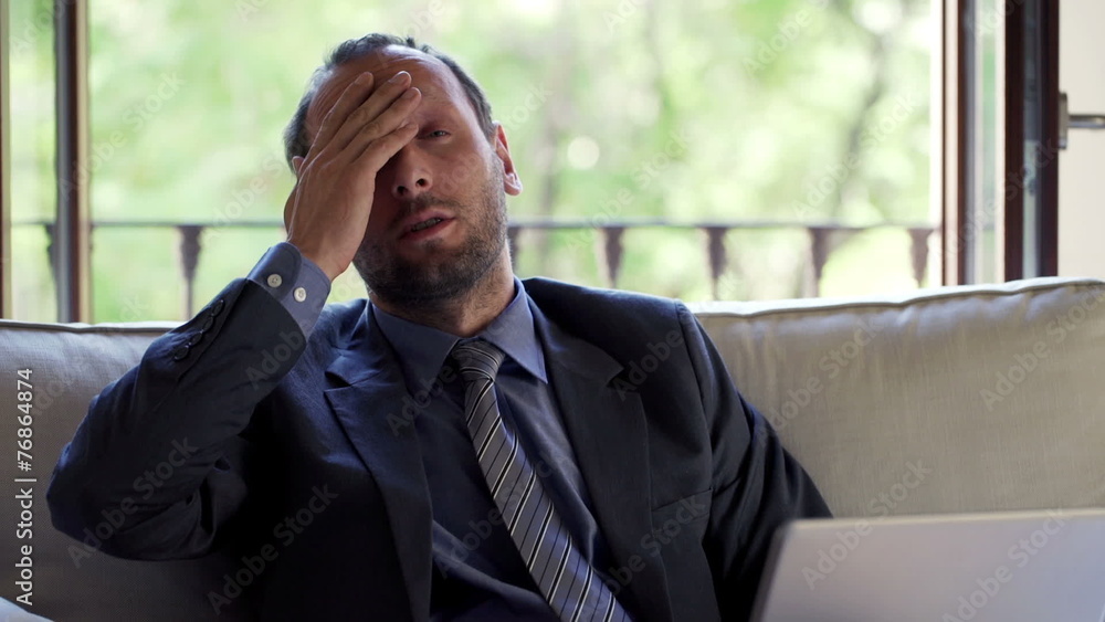 businessman having headache during work on laptop at home businessman having headache during work on laptop at home