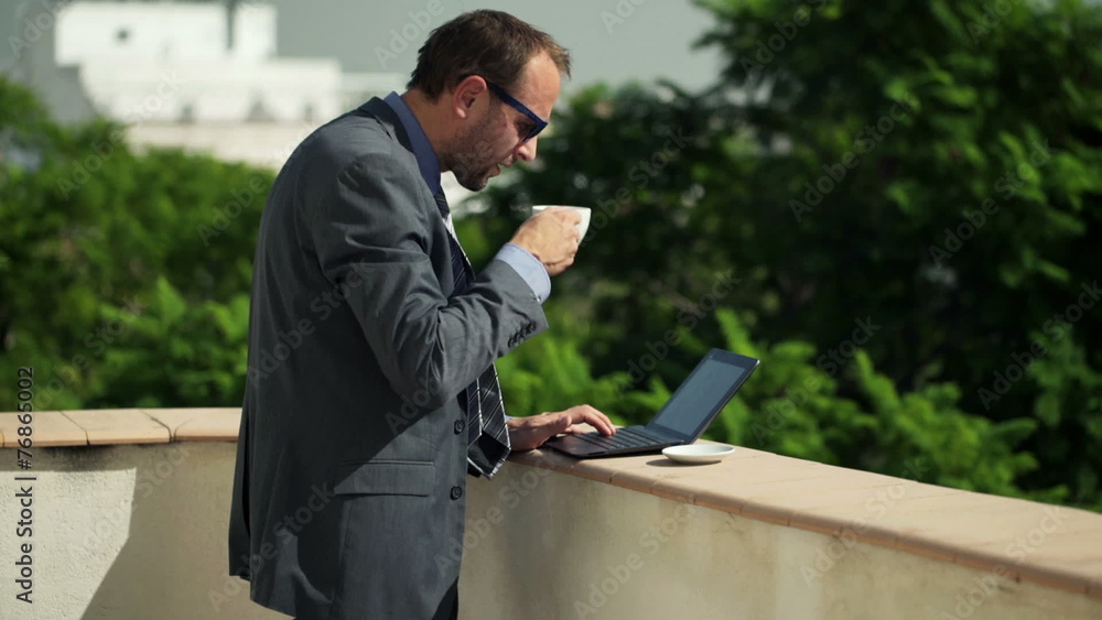 businessman working on laptop and drinking coffee on terrace businessman working on laptop and drinking coffee on terrace