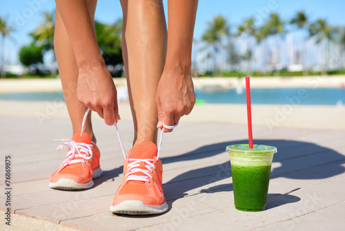 Running woman runner with green vegetable smoothie