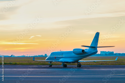 Business jet on the apron of aircraft. Dawn at airport