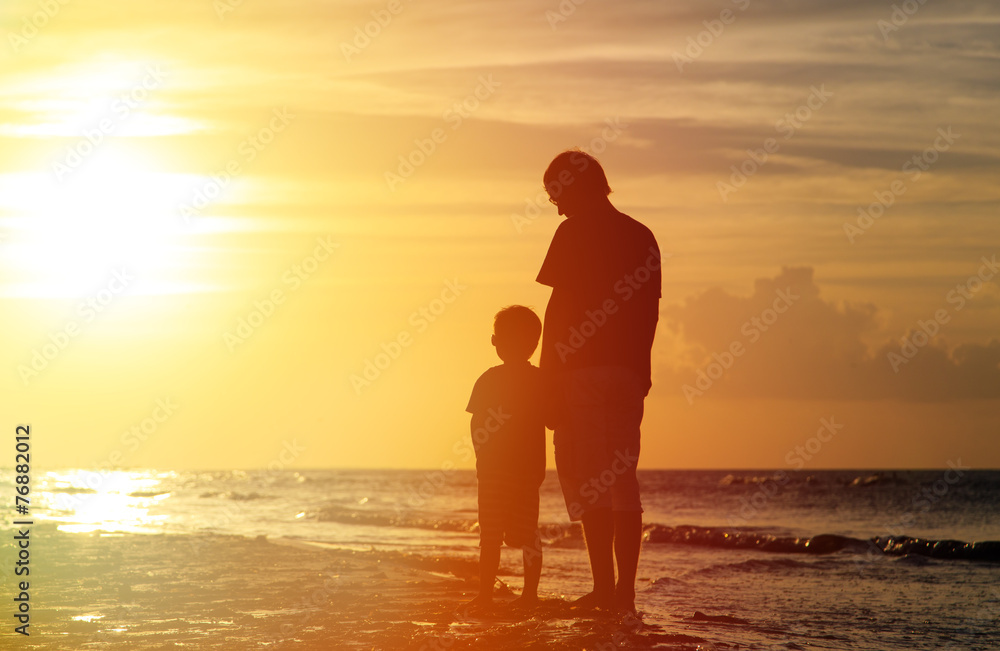 father and son holding hands at sunset