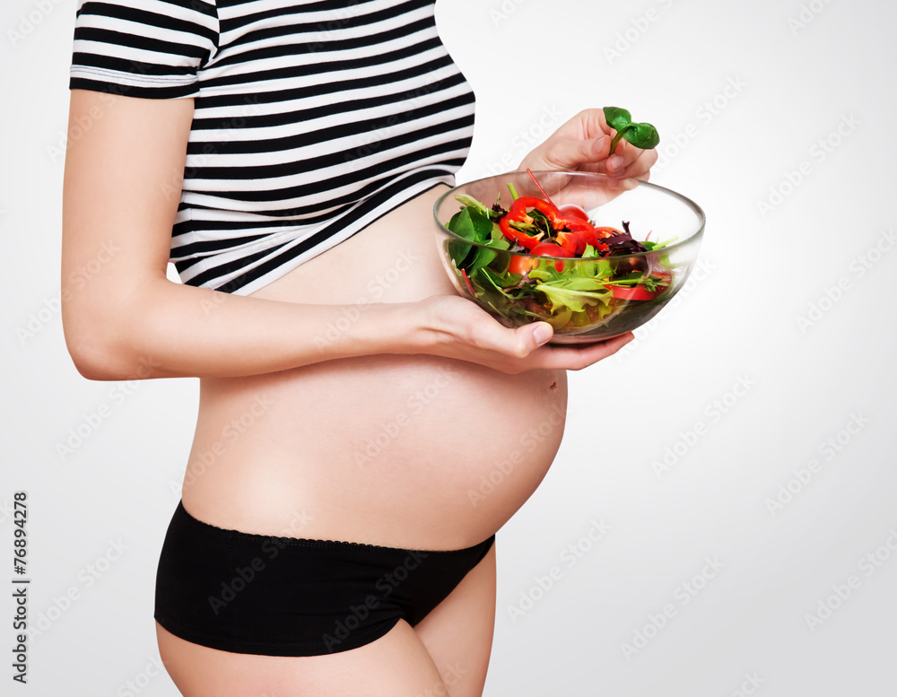 Pregnant woman with a bowl of vegetables Pregnant woman with a bowl of vegetables