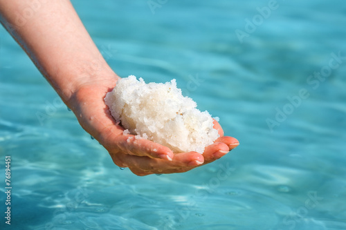 Bild auf Leinwand Female hand with sea salt for spa from Dead Sea
