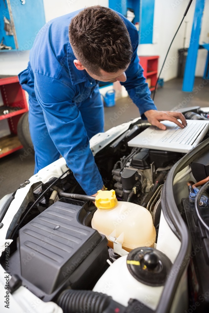Mechanic using laptop on car Mechanic using laptop on car