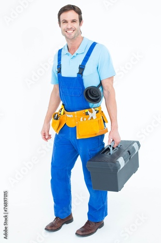 Happy plumber carrying tool box