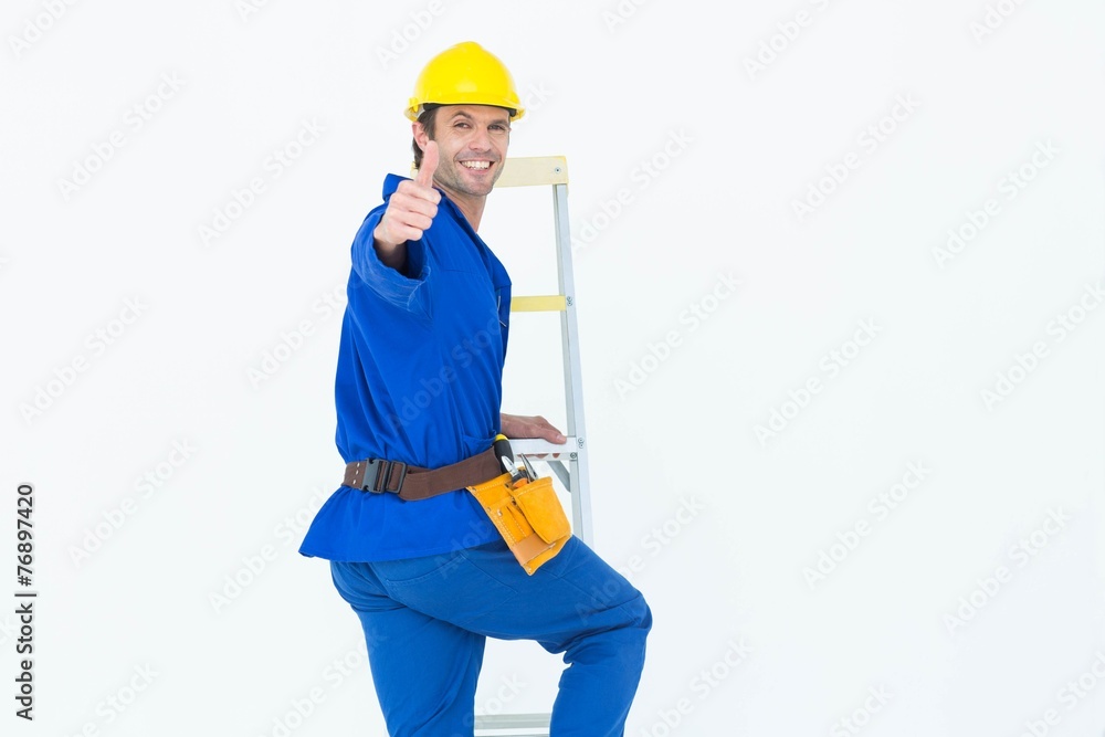 Repairman gesturing thumbs up while climbing step ladder Repairman gesturing thumbs up while climbing step ladder