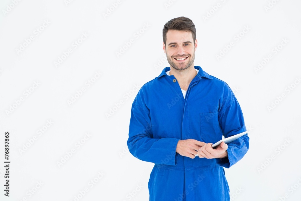 Happy young male mechanic using digital tablet Happy young male mechanic using digital tablet