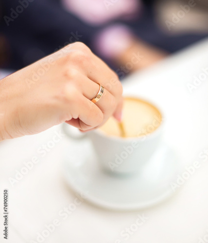 woman hand stir coffee in cafe