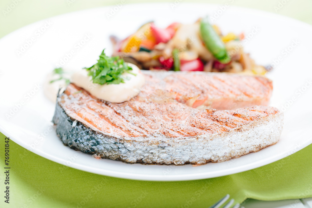Grilled Salmon with Fresh vegetables on green background