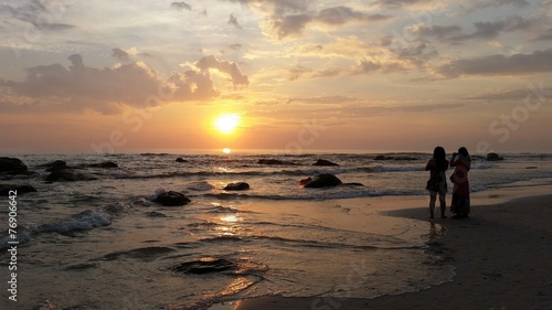 Women take a photo of sunrise at huahin beach Thailand