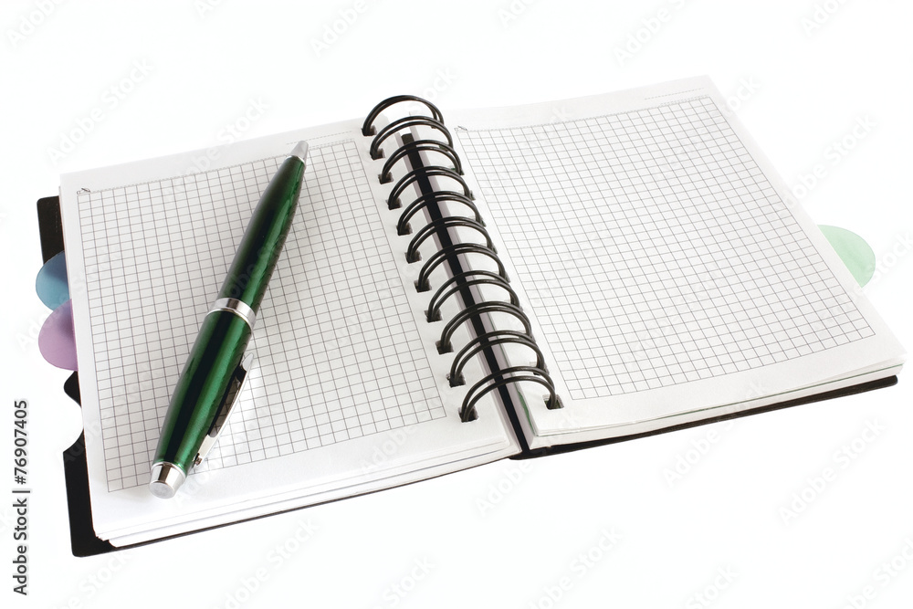 Open notebook with green pen Open notebook with green pen