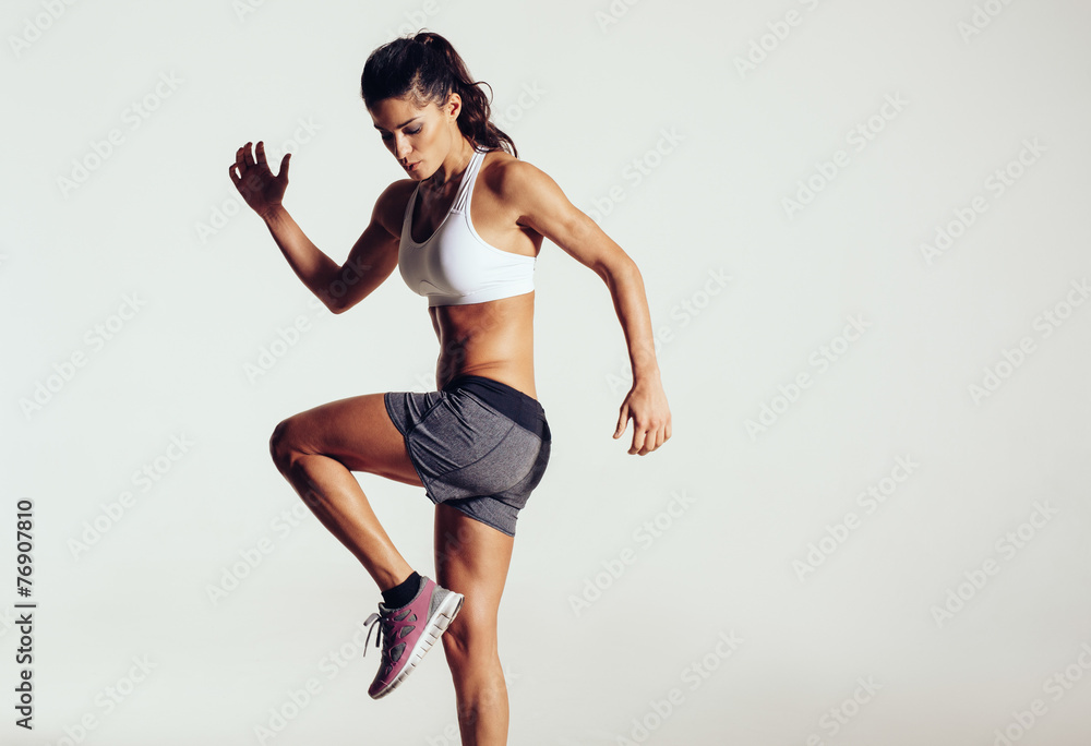 Attractive fit woman exercising in studio with copyspace