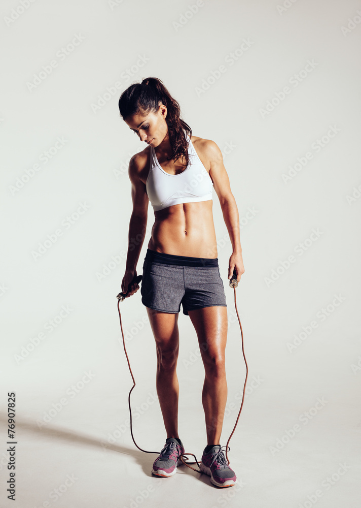 Fit and muscular woman with jumping rope