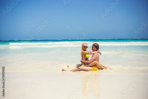 Cute couple resting on the shores of the azure sea