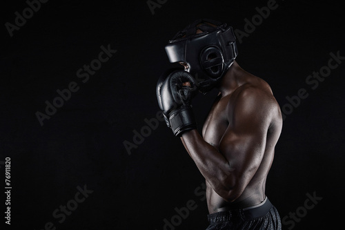 African male boxer blocking his face with gloves