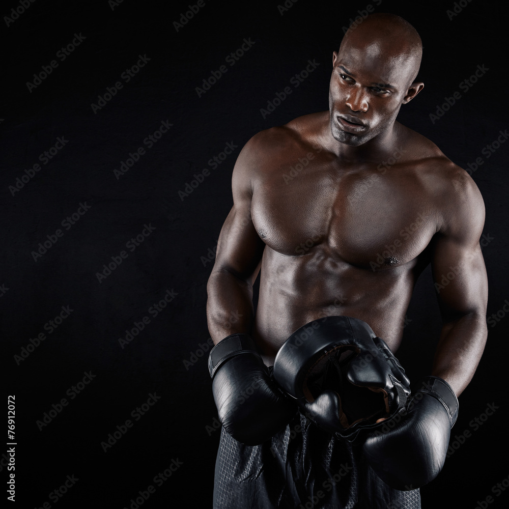 African male boxer against black background