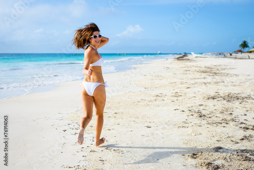 Playful woman having fun on tropical beach vacation
