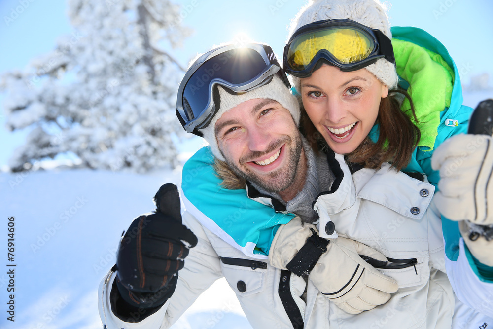Man giving girlfriend piggyback ride in the snowy mountain Man giving girlfriend piggyback ride in the snowy mountain