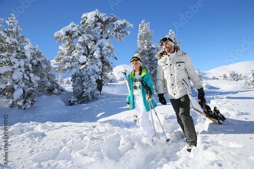 Skiers walking in snow track