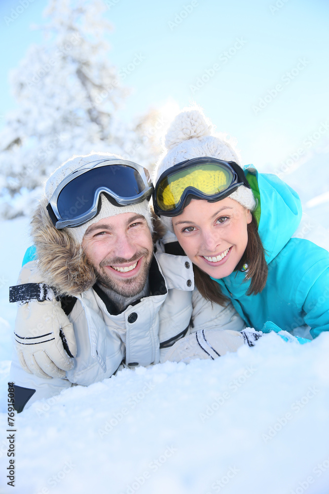 Portrait of loving couple of skiers in snowy moutain