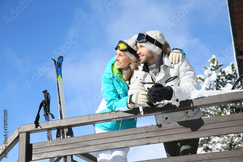 Couple of skiers admiring panorama from log cabin