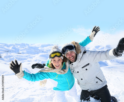 Cheerful couple of skiers having fun in the snow