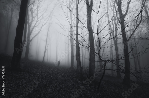 spooky forest landscape with man and twisted trees on halloween