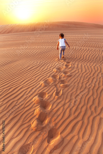 Baby - girl running in the desert.
