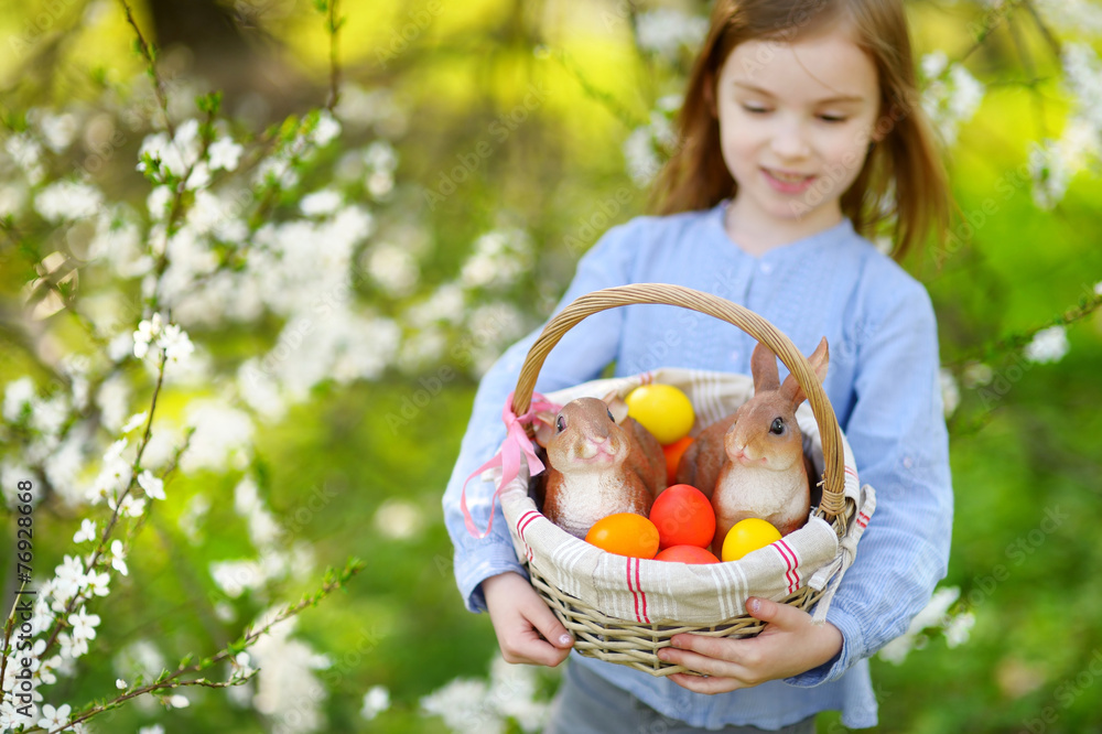 Adorable girl holding a basket of Easter eggs Adorable girl holding a basket of Easter eggs