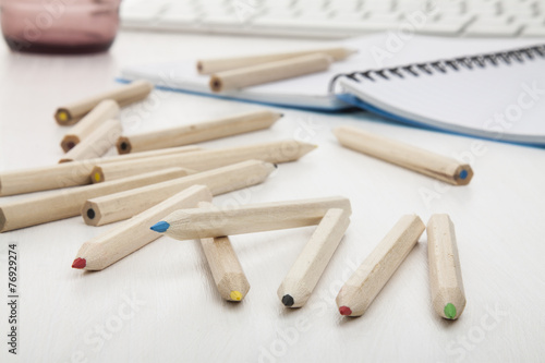 colored pencils on white wooden desk.