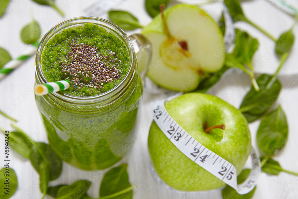Apple and spinach smoothie in glass on a wooden background Apple and spinach smoothie in glass on a wooden background