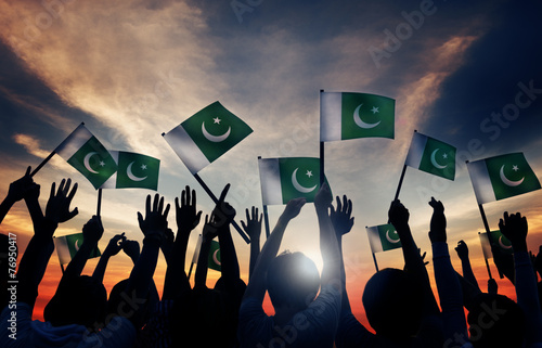 Group of People Waving Flag of Pakistan in Back Lit photo