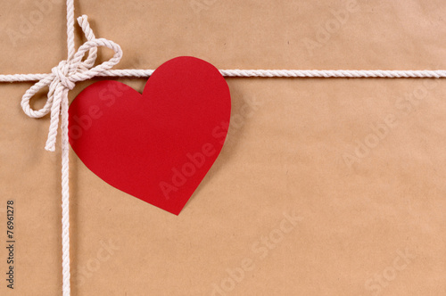 Brown paper package parcel background with red valentine heart shape card gift tag or love message photo