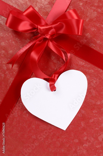 Valentine gift present red ribbon paper background and blank white message card or tag valentines day photo