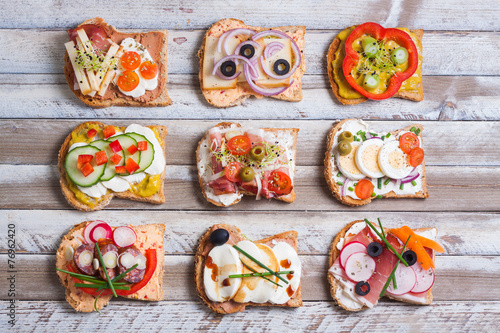 Sandwiches on wooden background, top view